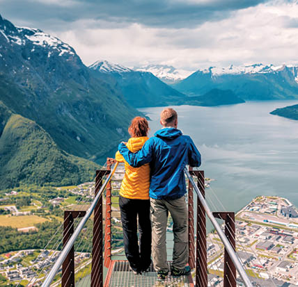 happy blue yellow couple tourists stands on rampestreken in Norway