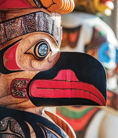 Alaska totem pole carving art sculture store in tourist travel attraction town on Alaska cruise. Ketchikan, Juneau, Skagway stores and shops selling native paintings and art. Closeup of an Eagle.